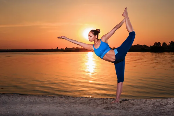 Yoga bei Sonnenuntergang am Strand. — Stockfoto