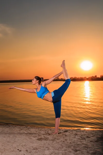 Yoga bei Sonnenuntergang am Strand. — Stockfoto