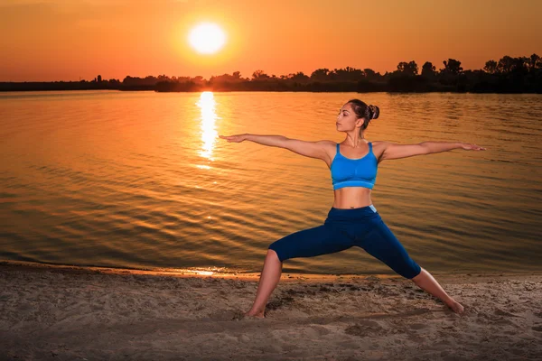 Yoga bei Sonnenuntergang am Strand. — Stockfoto