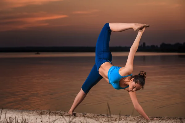 Yoga bei Sonnenuntergang am Strand. — Stockfoto