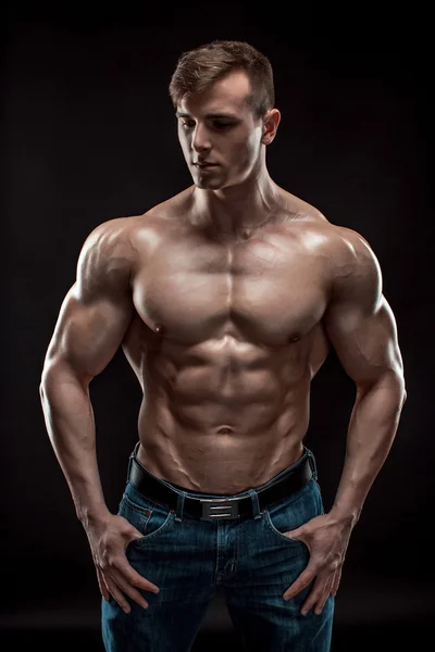 Muscoloso bodybuilder ragazzo facendo posa su sfondo nero — Foto Stock