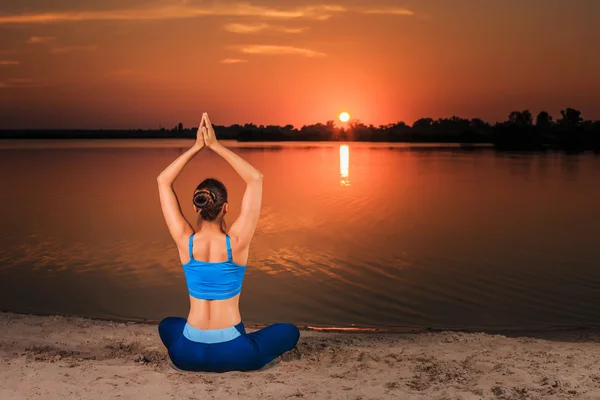 Yoga bei Sonnenuntergang am Strand. — Stockfoto