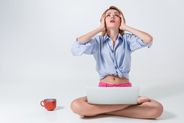 young woman sitting on the floor and using laptop clipart