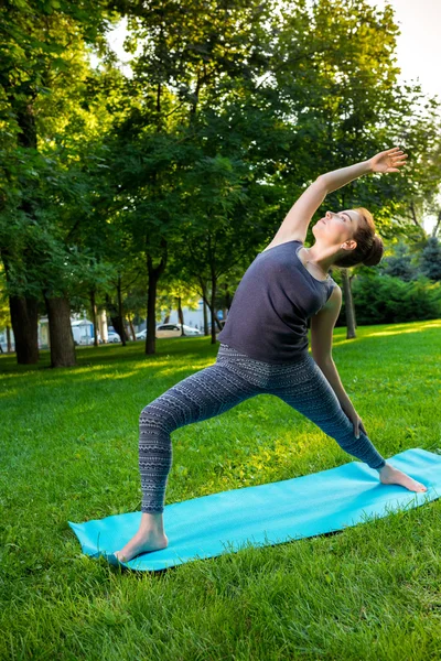 Fiatal nő csinál jóga gyakorlatok-a nyári városi park. — Stock Fotó