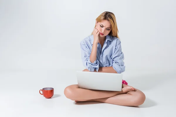 Молода жінка сидить на підлозі і використовує ноутбук — стокове фото