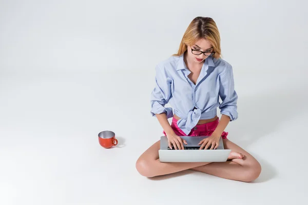 Jovem mulher sentada no chão e usando laptop — Fotografia de Stock