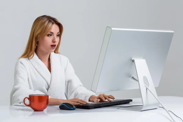 Mladá žena sedí v tabulce a pomocí počítače — Stock fotografie