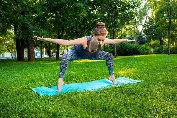 Fiatal nő csinál jóga gyakorlatok-a nyári városi park. — Stock Fotó