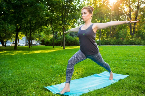 Genç kadının yaz Şehir Parkı yoga egzersizleri yapması.