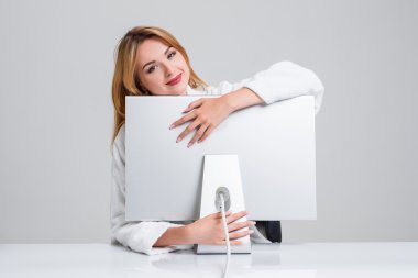 Tablo içinde oturan ve bilgisayarı kullanan genç kadın