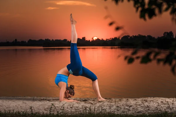 Yoga bei Sonnenuntergang am Strand. — Stockfoto