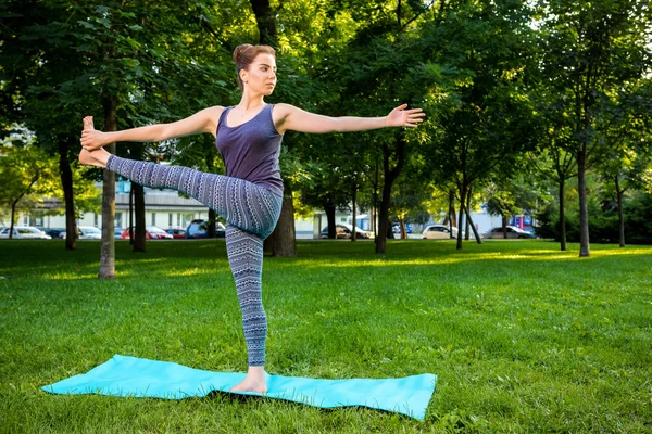 Junge Frau macht Yoga-Übungen im sommerlichen Stadtpark. — Stockfoto