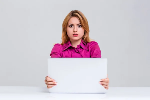 Jovem mulher sentada na mesa e usando laptop — Fotografia de Stock