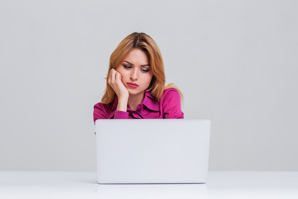 young woman sitting in the table and using laptop