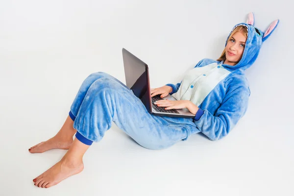 Lány pizsama, egy laptop, feküdt a padlón — Stock Fotó