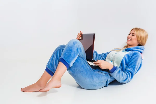 Дівчина в піжамі з ноутбуком лежить на підлозі — стокове фото