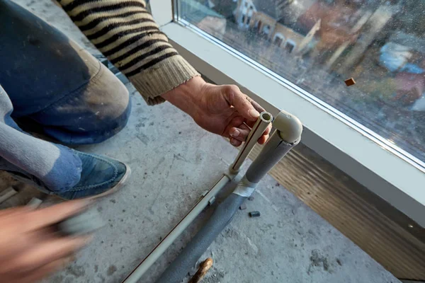Невідомий працівник встановлює пластикові труби в квартирі будівлі, що будується. Балкон багатоповерхового житлового будинку. крупним планом — стокове фото