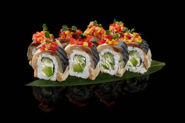 Siyah arkaplanda bambu yaprağı üzerinde uskumru filetosu ile rulo.