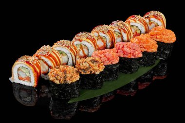 Gunkan maki and rolls with eel on bamboo leaf on black background clipart
