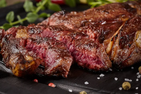 Closeup of sliced juicy veal steak with condiments and herbs — Stock Photo, Image