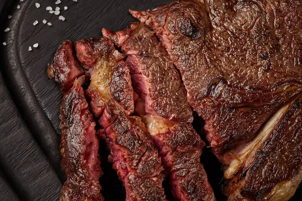 Closeup of sliced juicy beef striploin steak on wooden board — Stock Photo, Image