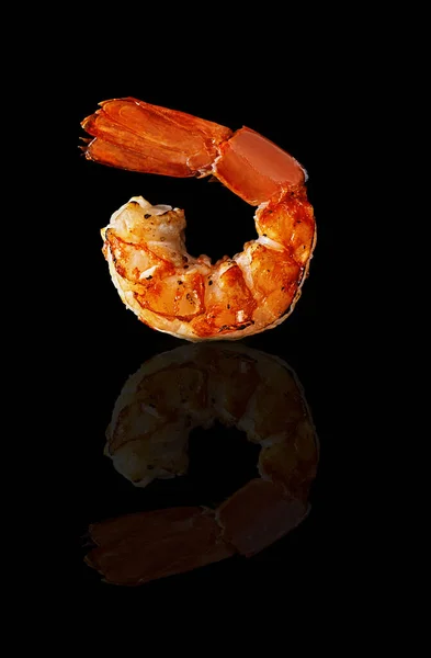 One grilled prawn tail on black background with reflection — Stock Photo, Image