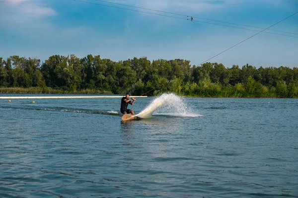 Sportig man rider på wakeboard på floden på sommardagen — Stockfoto
