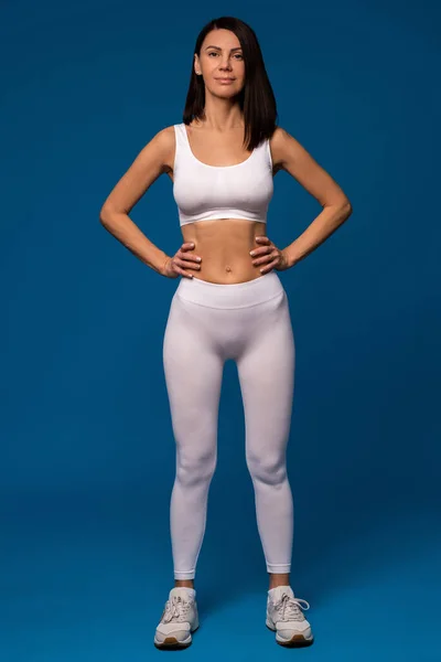 Спортивная женщина в белой одежде готова к тренировкам — стоковое фото