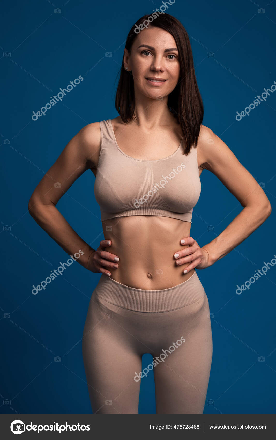 Front view of slim blonde woman with her arms akimbo as full body