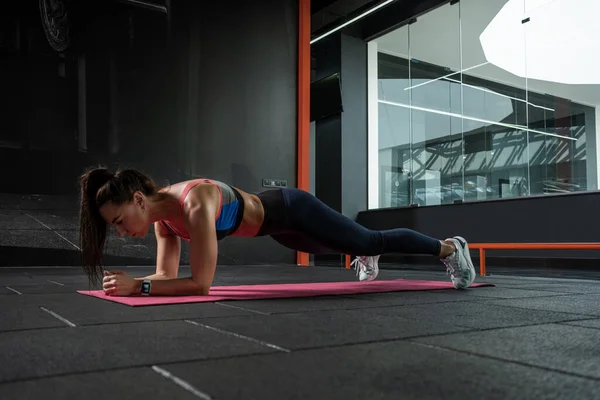 Fit Mädchen beim Ellbogenschlag auf Matte im Fitnessstudio — Stockfoto