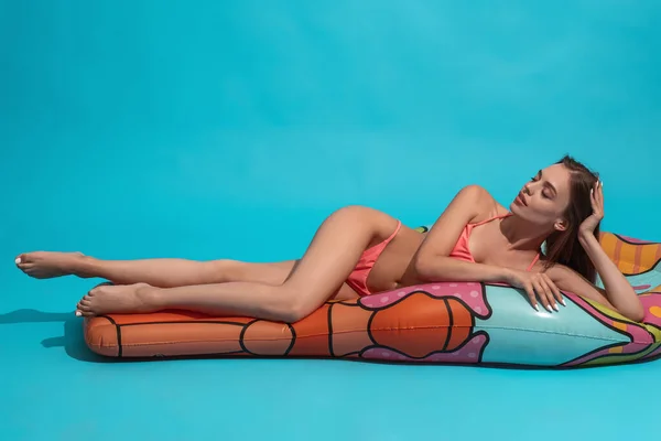 Entspannte Frau im Bikini liegt mit geschlossenen Augen auf aufblasbarer Matratze — Stockfoto