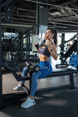 Fit esmer makine üzerinde sırt kasları için egzersiz yapıyor.