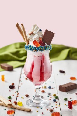 Berry milkshake with whipped cream, chocolate waffles, gummy bears