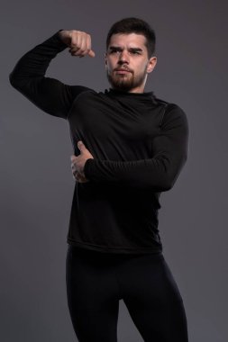 Young athlete posing on grey studio background