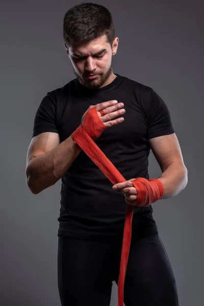 Focused young man wrapping hands with boxing tape — 스톡 사진