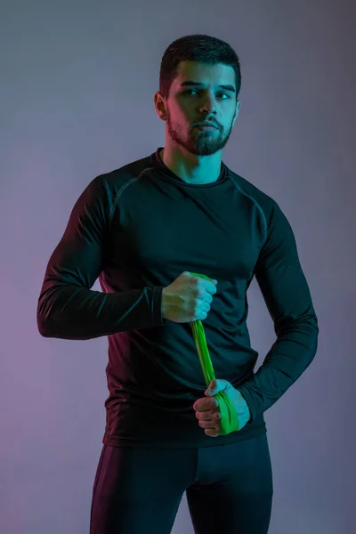 Athletic guy posing with resistance band in hands — Fotografia de Stock