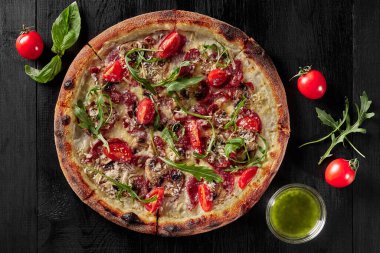 Cabanossi, salam, pastırma, jambon ve parmesanlı pizza manzarası.