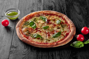 Domates soslu pizza, mozzarella, fesleğen ve pesto.