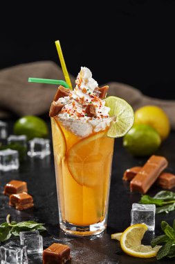 Lemonade with lime and orange topped with whipped cream and toffees clipart