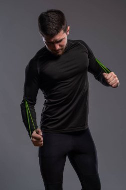 Odaklanmış sporcu adam direniş bandı egzersizi yapıyor.