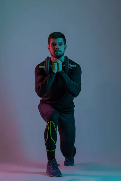 Jovem desportivo fazendo lunges frente com halteres — Fotografia de Stock