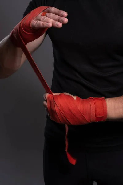 Αρσενικά χέρια τυλιγμένα με κόκκινη ταινία πυγμαχίας πριν τον αγώνα — Φωτογραφία Αρχείου