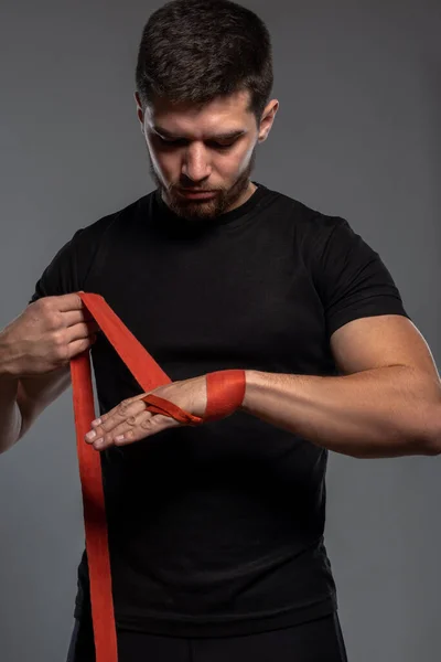 Joven envolviendo las manos con cinta roja de algodón — Foto de Stock