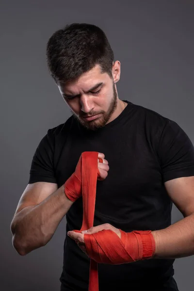Junger Kämpfer wickelt Hände mit Baumwollband — Stockfoto