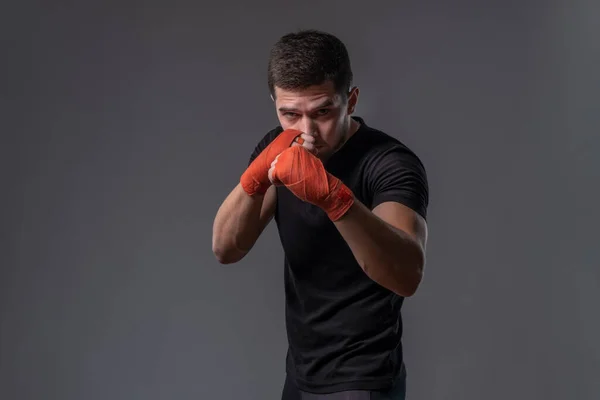 Luchador joven enfocado con las manos envueltas de pie en postura ortodoxa —  Fotos de Stock