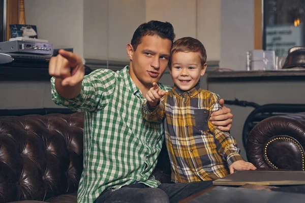 Mladý otec a jeho stylový malý syn v holičství v čekárně. — Stock fotografie
