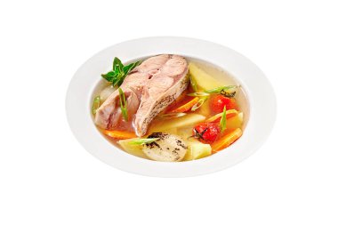 Beyaz arka planda balık çorbası, sazan bifteği ve sebze.