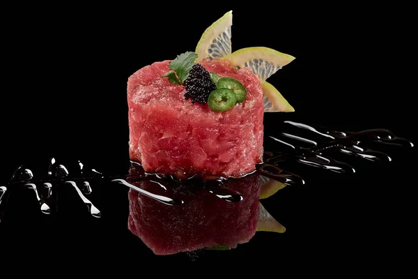 Raw tuna tartare with tobiko, lime, greens and soy sauce