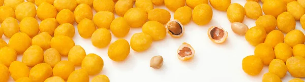 Gula salta rostade jordnötter med baconsmak på vit yta — Stockfoto