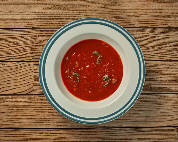 Тарілка густого томатного супу в м'ясному бульйоні на дерев'яному фоні — стокове фото